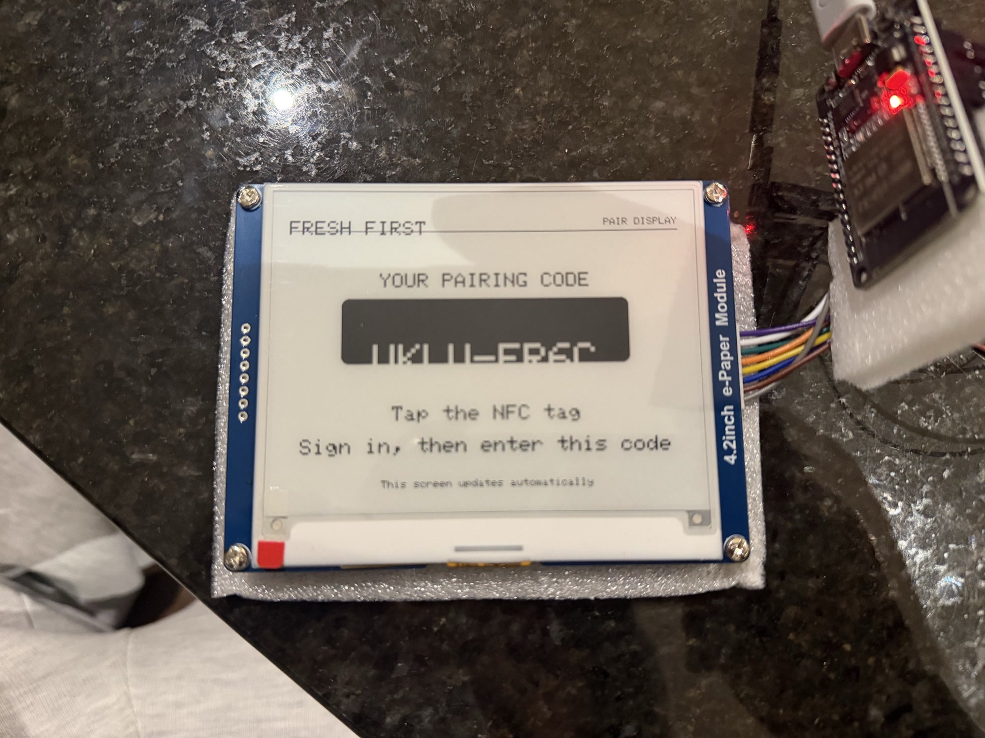 An early pairing code rendered partly outside the e-paper display layout.