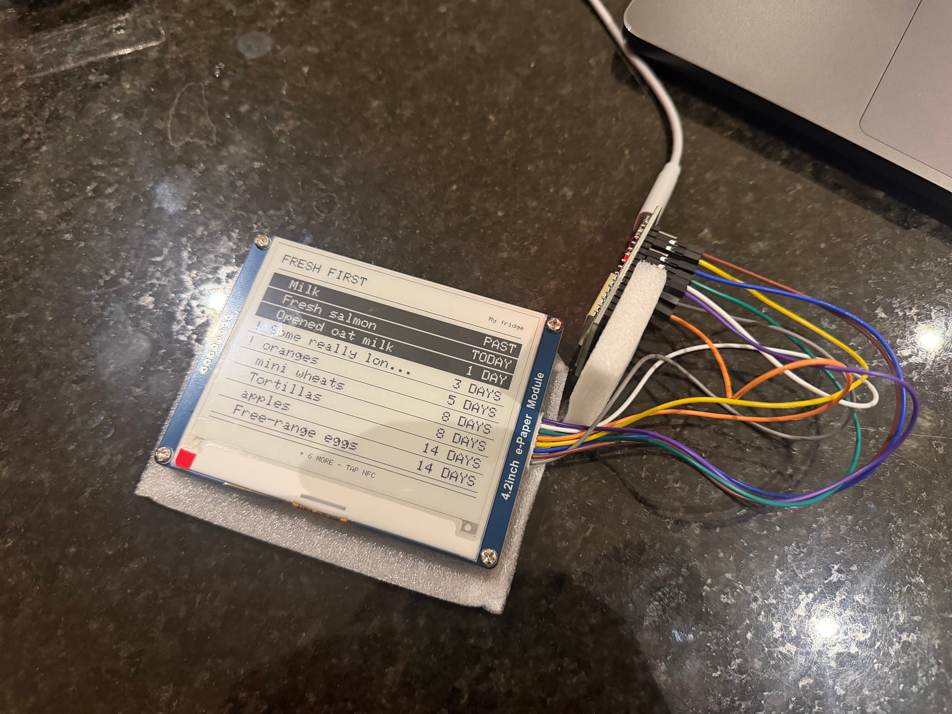 An early Fresh First bench prototype with the live e-paper fridge list wired directly to its controller.