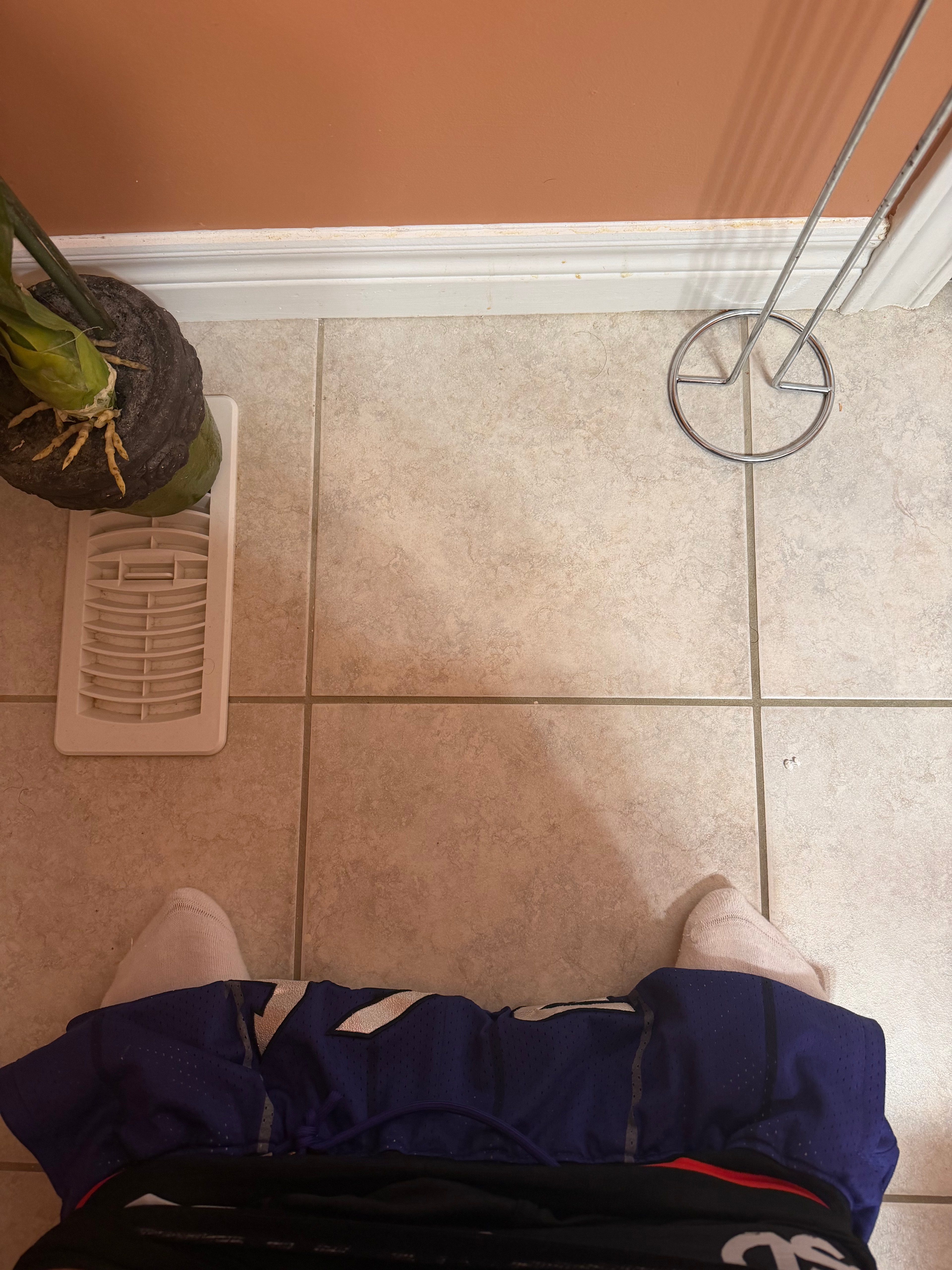 Shaaf's shoes, a blue jersey, and the fixtures of a warmly lit restroom.