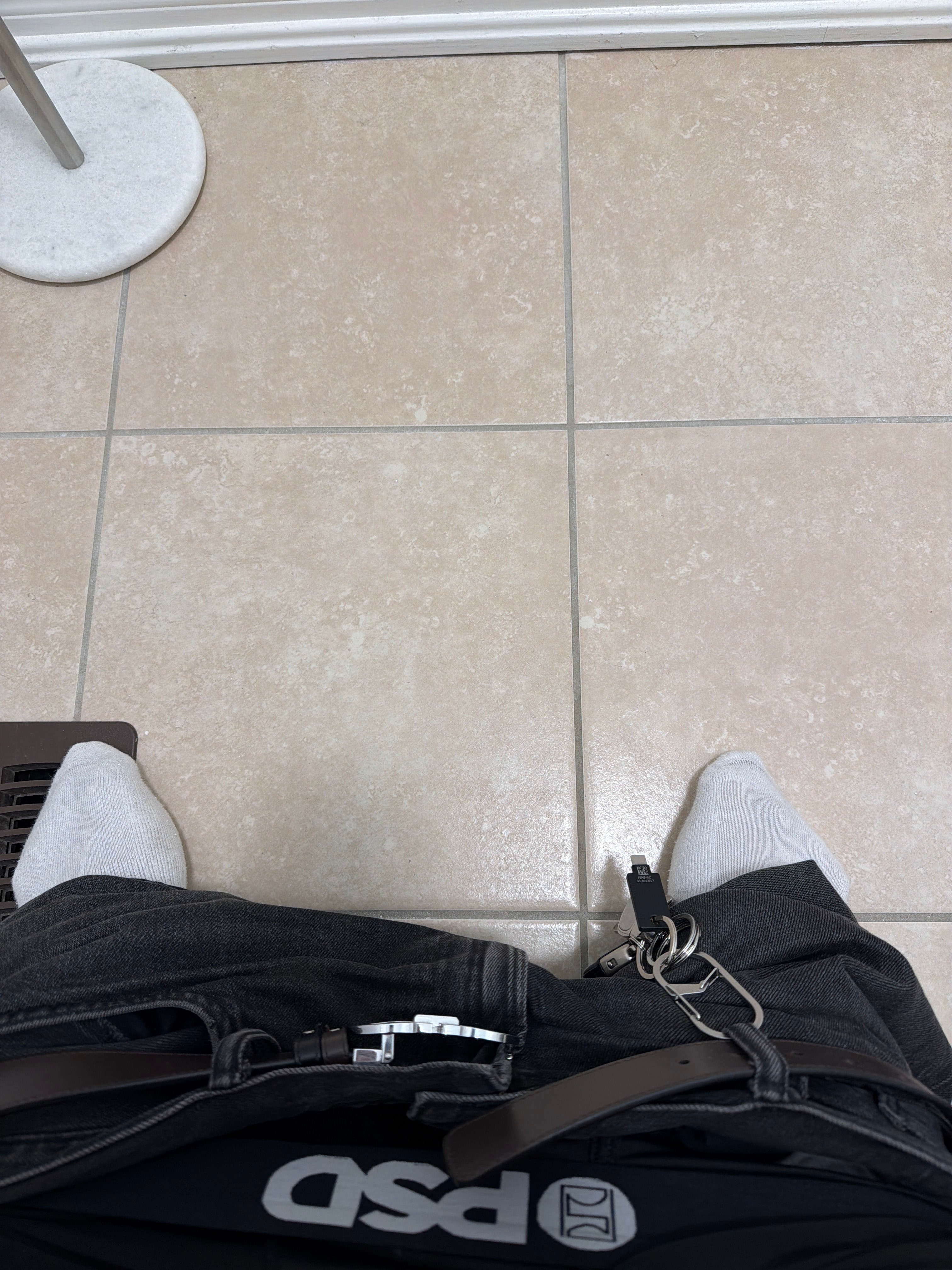 Shaaf's shoes and keys against a restroom's beige tiled floor.